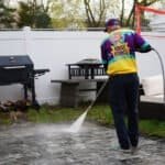 Rinse Prince technician cleaning a stone patio with a pressure washer